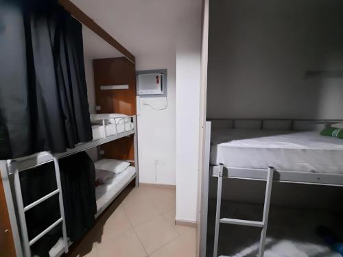 a room with two bunk beds and a ladder at Soul do Mar Hostel in Cabo Frio