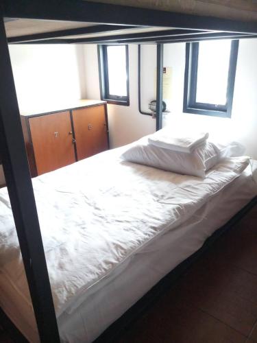 a bed in a room with at The Guest Hotel & Hostel in Chiang Mai