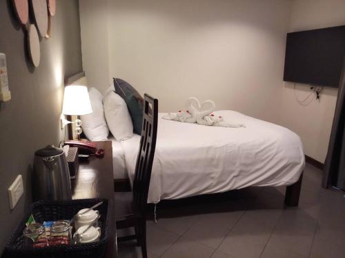 a bedroom with a bed with a stuffed animal on it at The Guest Hotel & Hostel in Chiang Mai
