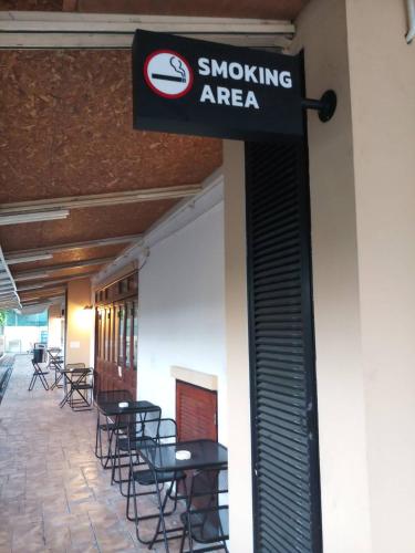 a sign for a smoking area on the side of a building at The Guest Hotel & Hostel in Chiang Mai