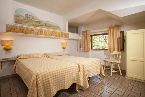 a bedroom with a bed with a yellow and white checkered blanket at Le Roccette Club in Tropea