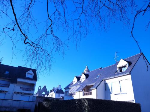 a row of white buildings with a blue sky in the background at LE NID DE BATZ SUR MER-Studio-Les Gîtes de la Côte d'Amour in Batz-sur-Mer