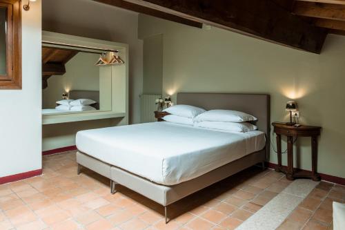 a bedroom with a white bed and a mirror at Osteria Luxury Apartments in Peschiera del Garda