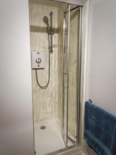 a shower with a glass door in a bathroom at Sunnyside in Camber