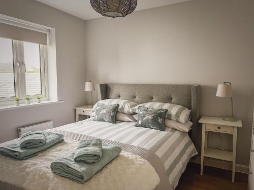 a bedroom with a bed with two towels on it at Sunnyside in Camber