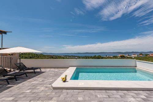 ザダルにあるVilla Pava ZadarVillasの家のパティオにあるスイミングプール