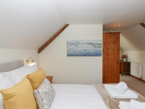a bedroom with a white bed and a wooden cabinet at Dove Cottage in South Molton