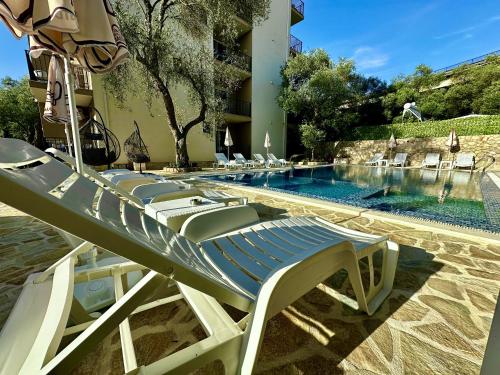 a swimming pool with lounge chairs next to a hotel at Akhdar Apartments in Utjeha