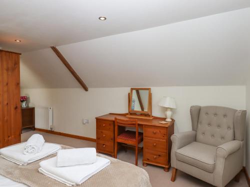 a bedroom with a desk and a chair and a mirror at Dove Cottage in South Molton