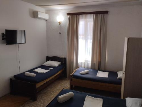 a hotel room with two beds and a window at Ortachala Summer House in Tbilisi City