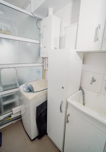 a white bathroom with a toilet and a sink at Hermoso departamento en primeria línea in Iquique