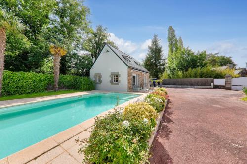 une maison avec une piscine à côté d'un bâtiment dans l'établissement Maison pour 8 avec piscine 500m de la plage, à Arradon
