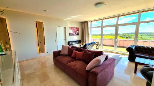 a living room with a couch and a large window at Deluxe Apartment mit Sauna, gehobene Ausstattung, Sydney in Schwarzenbek