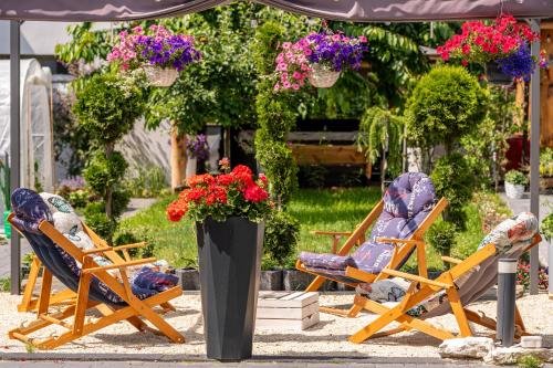 two lawn chairs and two chairs with flowers at Wynajem grupowy Szansa in Mrągowo