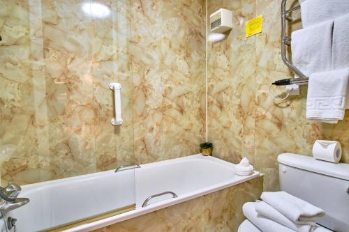 a bathroom with a bath tub and a toilet at Muthu Ben Doran Hotel in Tyndrum