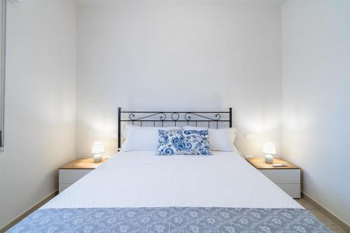 a bedroom with a large white bed with two night stands at Littiricci in Marzamemi