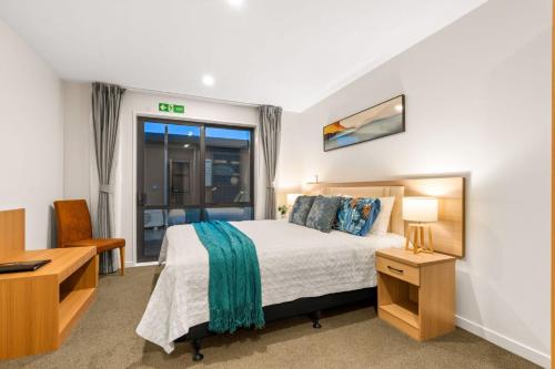 a bedroom with a bed and a desk and a window at Starlet 11 in Lake Tekapo
