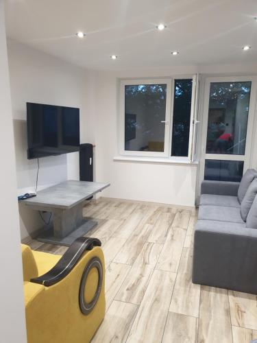 un soggiorno con un divano, un tavolo e una TV di Sikalafo1 a Płock