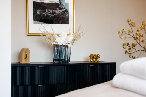 a vase of flowers on a black dresser in a bedroom at Chata Kloučka Stříbrná Skalice in Stříbrná Skalice