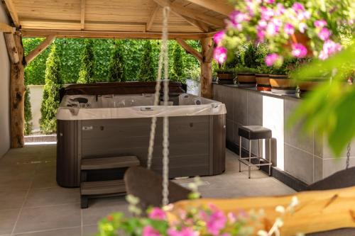 a outdoor hot tub in a pavilion with plants at Wynajem grupowy Szansa in Mrągowo