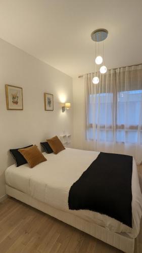 une chambre avec un grand lit et une fenêtre dans l'établissement La Clé de Thierry, à Le Vésinet