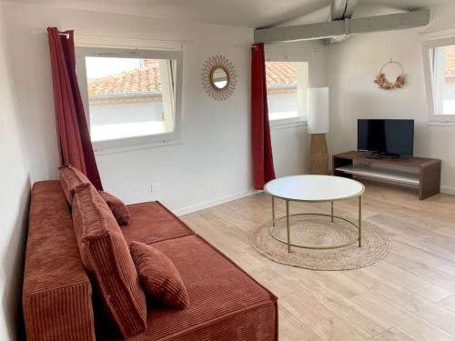 un salon avec un canapé et une table dans l'établissement Le Panoramique, à Castres