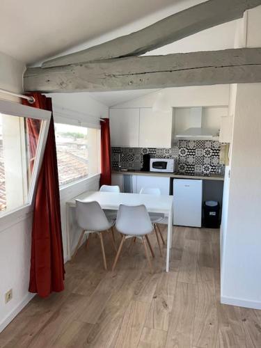 une cuisine avec une table et des chaises dans une pièce dans l'établissement Le Panoramique, à Castres