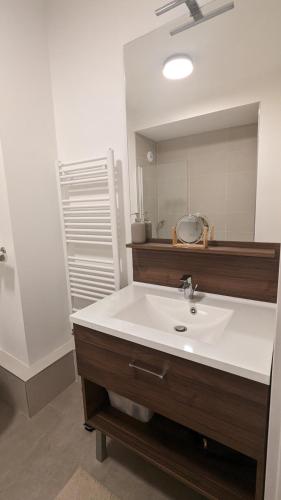 une salle de bain avec un lavabo et un miroir dans l'établissement La Clé de Thierry, à Le Vésinet