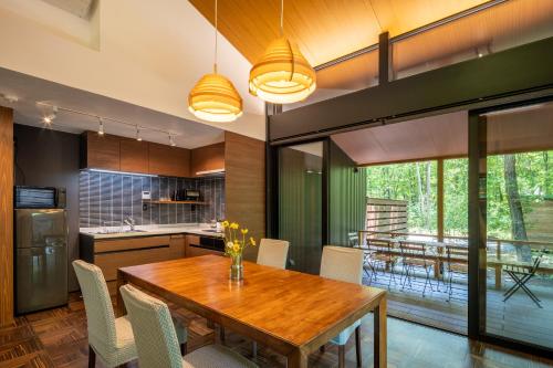 a kitchen and dining room with a wooden table and chairs at 森の宿り 時庵 まるやま in Nasu