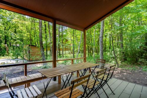 a screened in porch with a wooden table and chairs at 森の宿り 時庵 まるやま in Nasu