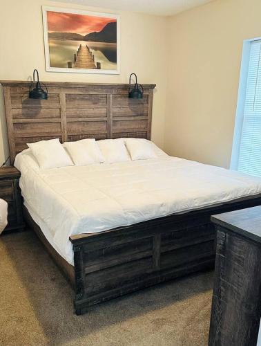 a bedroom with a large bed with a wooden headboard at The Great Escape King suite, Kid friendly in Sevierville