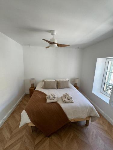 une chambre avec un lit avec un ventilateur de plafond dans l'établissement La Halte des Arènes de Nîmes Nude Beauté du Minimalisme, à Nîmes