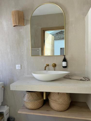 une salle de bain avec un lavabo et un miroir dans l'établissement La Halte des Arènes de Nîmes Nude Beauté du Minimalisme, à Nîmes