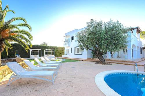 a row of lounge chairs next to a swimming pool at INIBIZA VILLAS - Villa Oasis in Sant Jordi