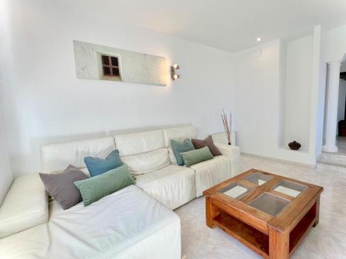 a living room with a white couch and a coffee table at INIBIZA VILLAS - Villa Oasis in Sant Jordi
