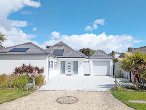 a house with a white garage at One Elms Way - Sleeps 8 - West Wittering in West Wittering