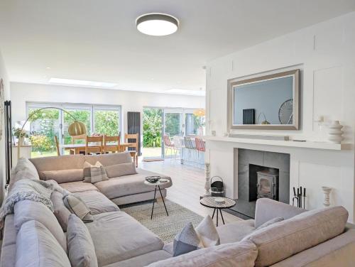 a living room with a couch and a fireplace at One Elms Way - Sleeps 8 - West Wittering in West Wittering