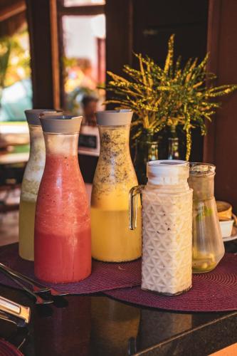 een groep van vier vazen in verschillende kleuren op een tafel bij Pousada Meeting Point & KiteSchool in Cumbuco