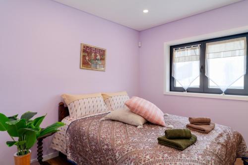 a bedroom with a bed with pillows and a window at Porto Vivenda em Lever-casa inteira in Lever