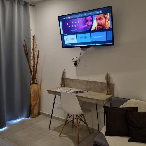 a television hanging on a wall in a living room at AZ Suites Resistencia in Resistencia