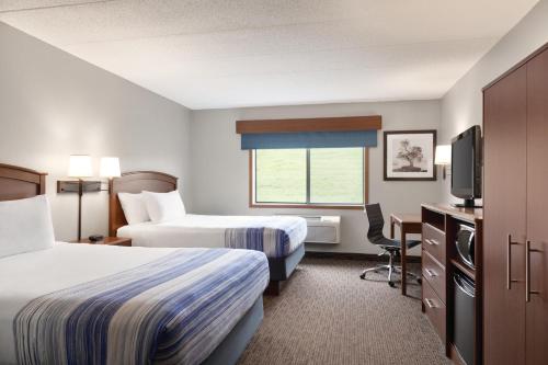 a hotel room with two beds and a television at AmericInn by Wyndham Fergus Falls Conference Center in Fergus Falls