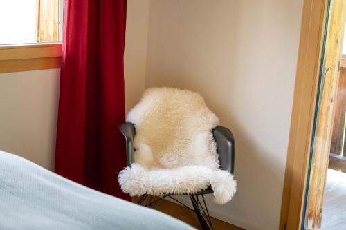 a teddy bear sitting on a chair in a room at Haus Birke - Alpenglück in Obergesteln