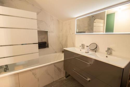 une salle de bain avec un lavabo, une baignoire et un miroir dans l'établissement Loft atelier hyper centre Albi, à Albi