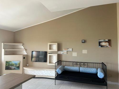 a room with a couch and a flat screen tv at Giardino Sul Mare in Vibo Valentia