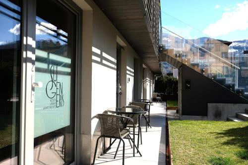 a patio with chairs and tables on the side of a building at Sui Generis - Aosta Urban Apartments in Aosta