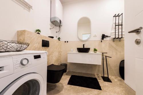 - une buanderie avec un évier et un lave-linge dans l'établissement Marijano Central Apartments, à Split