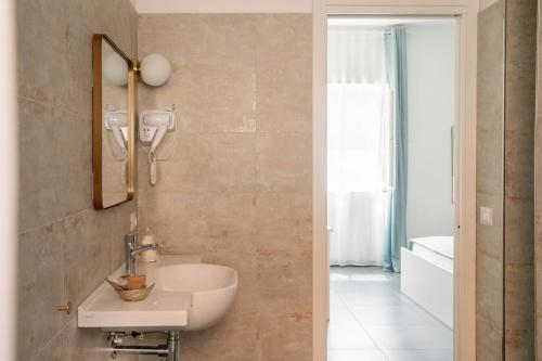 圣塔马里亚迪卡斯特DomusEli的墙上有水槽和镜子的浴室