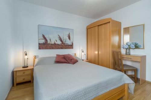 a bedroom with a bed and a desk with a chair at Apartments Bellissima in Funtana