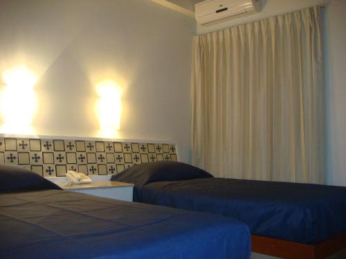 a hotel room with two beds and lights on the wall at Hotel Roma in Cosamaloapan de Carpio