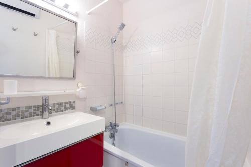une salle de bain avec un lavabo, une baignoire et un miroir dans l'établissement Villa 40m2 cosy avec piscine, clim, parking privé, à La Grande Motte